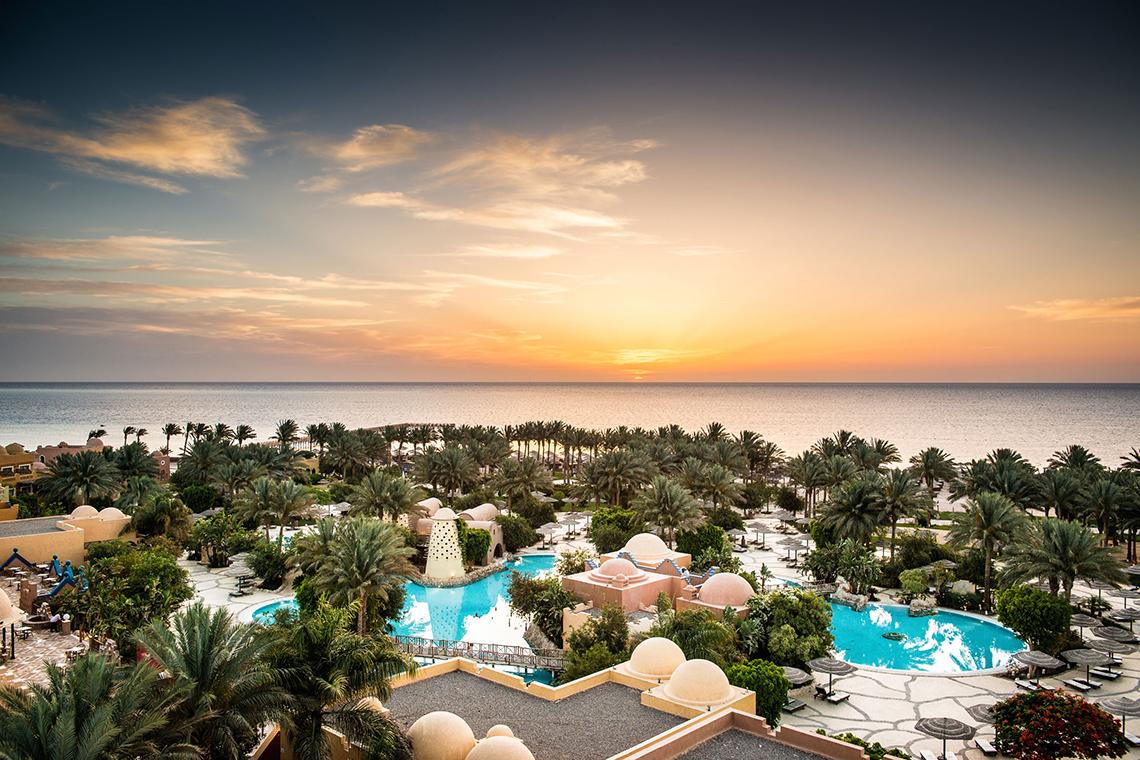 Luftaufnahme des Grand Makadi Hotels mit Swimmingpools und Meer im Hintergrund.