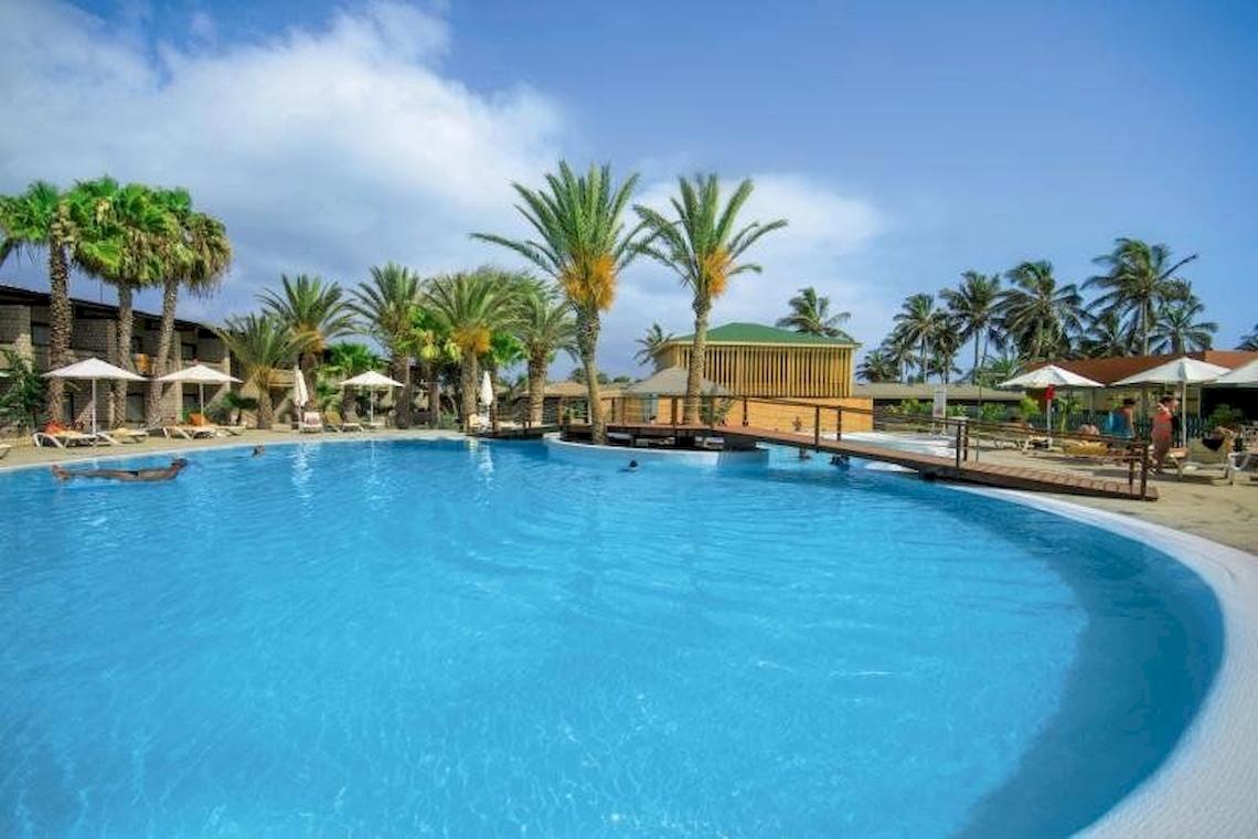 Außenpool des Oasis Belorizonte Hotels mit Palmen und Sonnenliegen