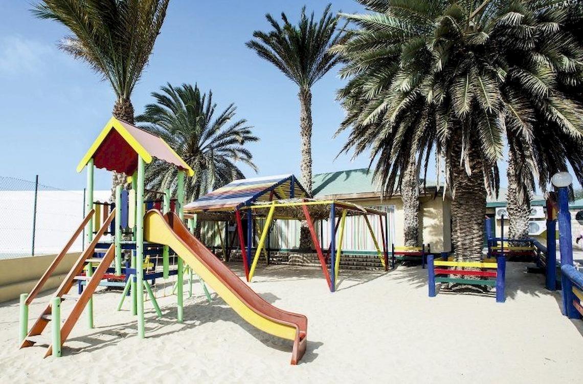 Spielplatz im Oasis Belorizonte Hotel, bunte Spielgeräte unter Palmen