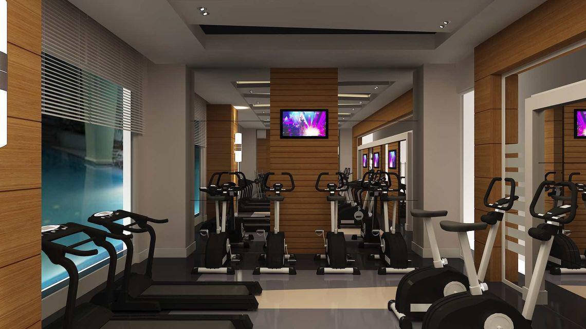 Fitness Center im Side Sunport Hotel & Spa mit verschiedenen Trainingsgeräten und Fernsehern an der Wand.