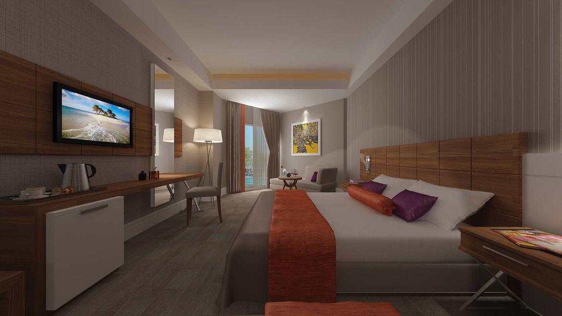 Schlafzimmer im Side Sunport Hotel & Spa mit Fernseher, Schreibtisch, Sessel und Aussicht auf das Meer.