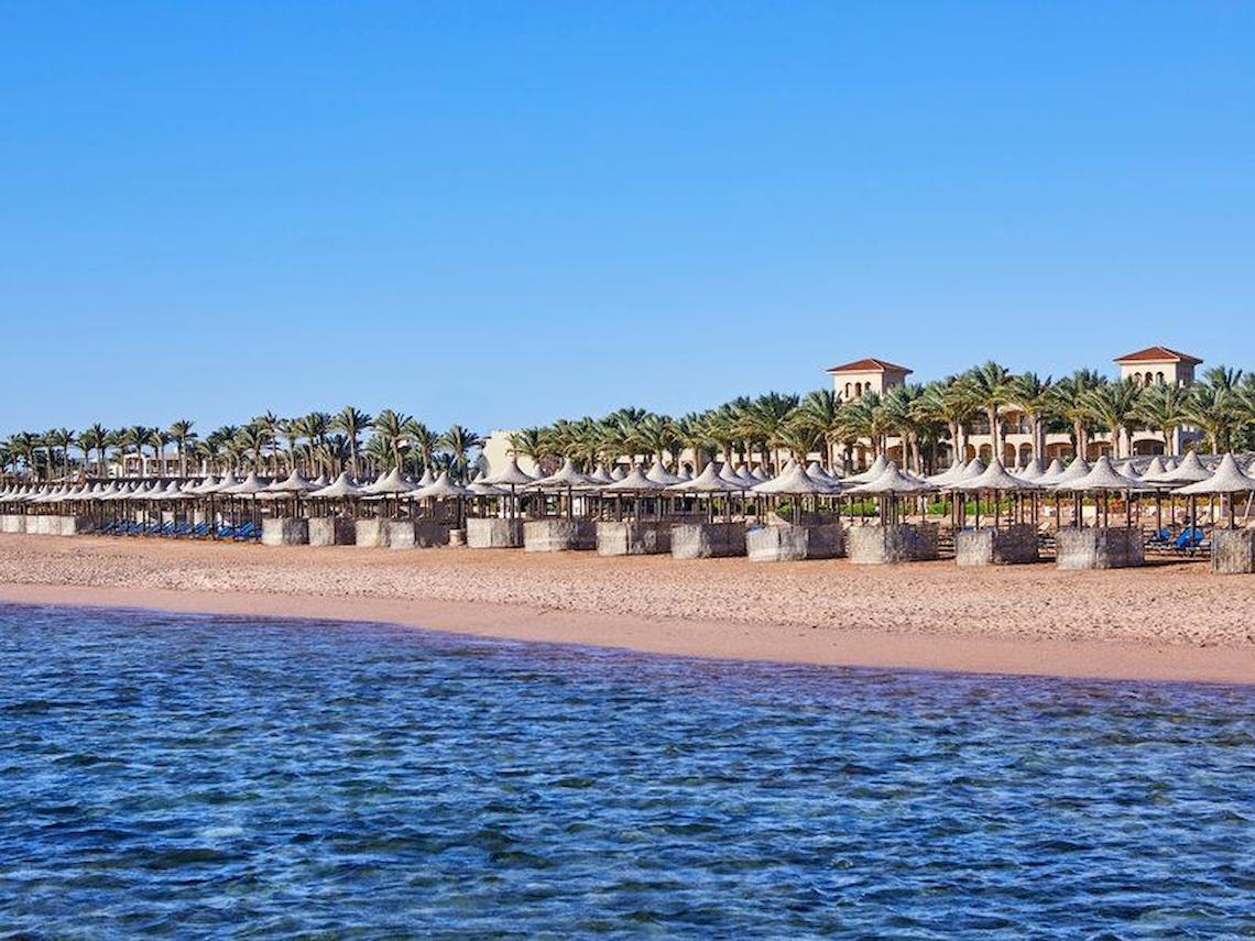 Strand mit Sonnenschirmen und Jaz Mirabel Beach Hotel im Hintergrund