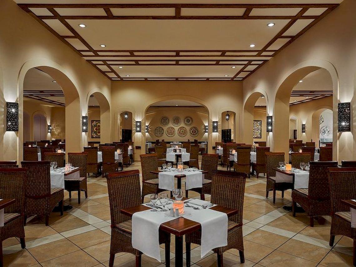 Innenansicht des Jaz Mirabel Beach Restaurants mit gedeckten Tischen und Stühlen.