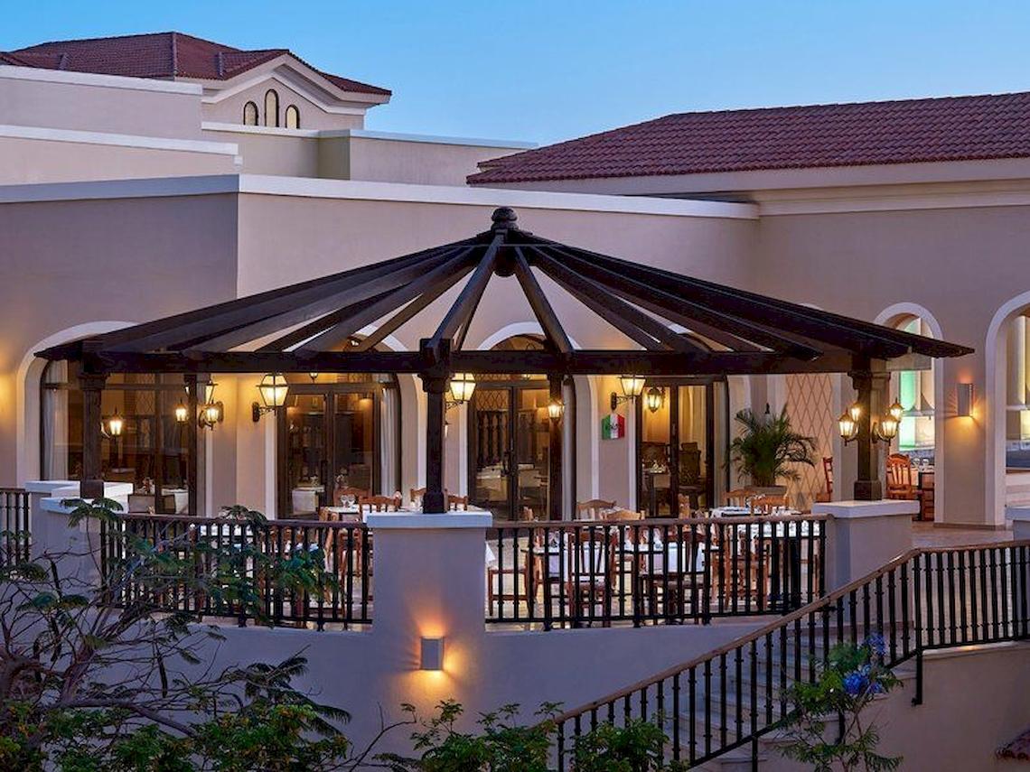 Außenbereich des Jaz Mirabel Beach Hotels mit beleuchteter Überdachung und Tischen.