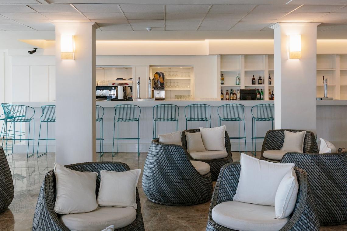 Lounge Bereich im Leonardo Royal Hotel Ibiza Santa Eulalia mit Sitzmöbeln und Bar.