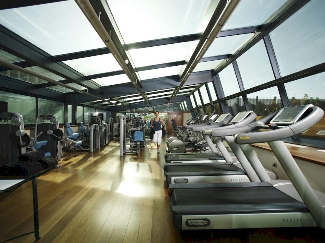 Fitnessstudio im Gewölbe mit Laufbändern und Frau im Hintergrund