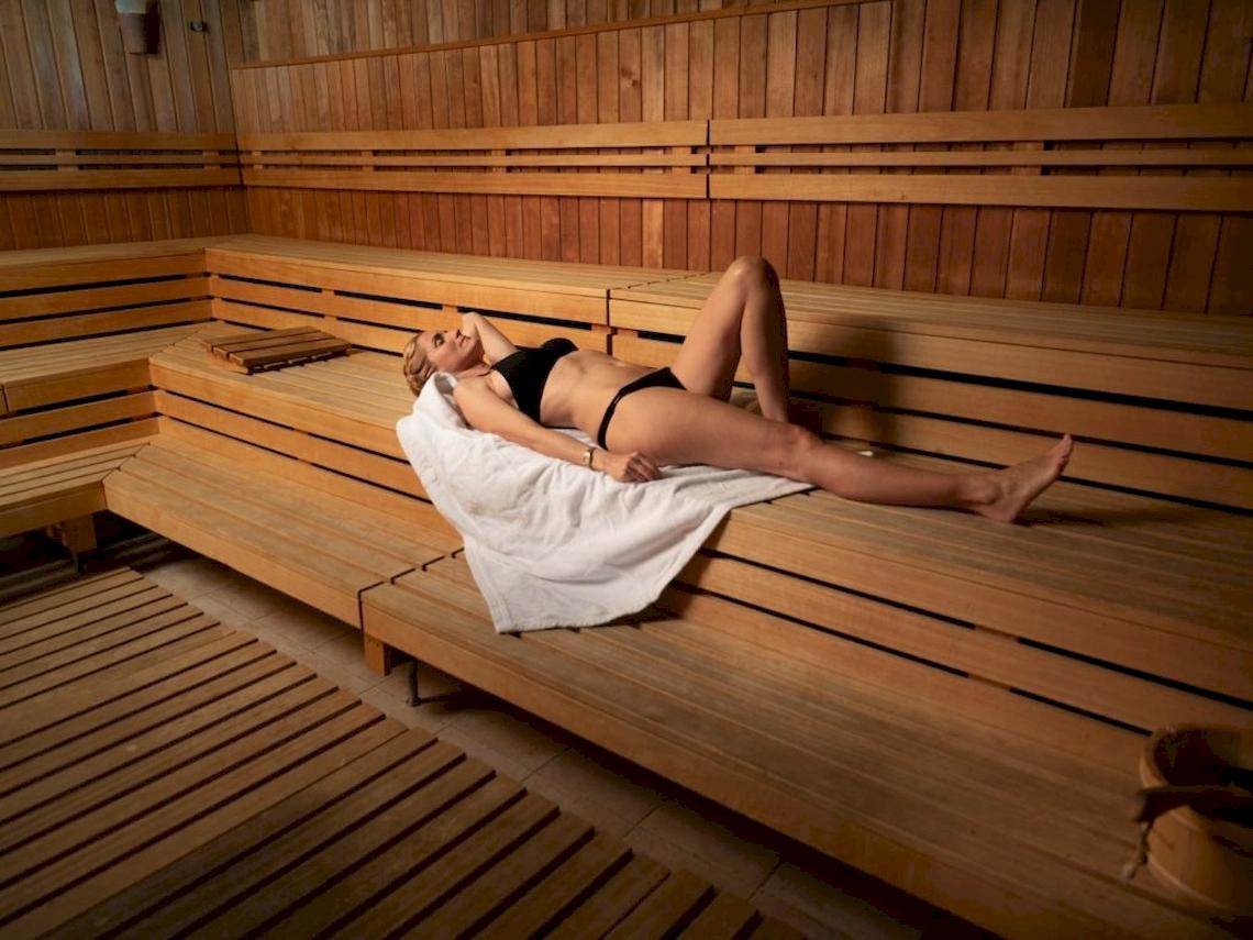 Frau in Holzsauna im Hotel Secrets Bahia Real Resort & Spa