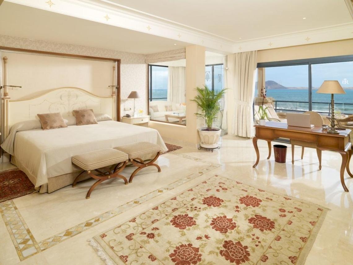 Schlafzimmer der Suite im Secrets Bahia Real Resort & Spa mit Meerblick und modernen Möbeln