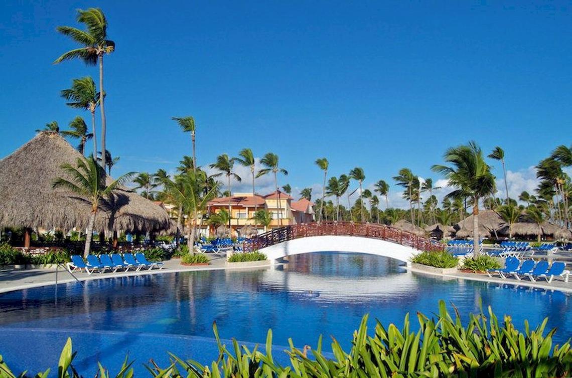Außenpool mit Brücke und Liegestühlen im Bahia Principe Grand Turquesa Hotel.