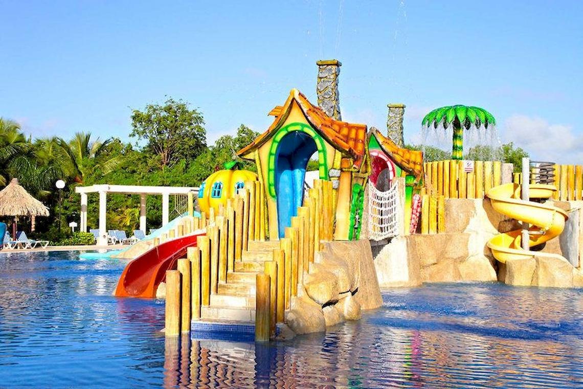 Kinderspielplatz im Bahia Principe Grand Turquesa Hotel mit bunten Rutschen und Wasserspielstationen.