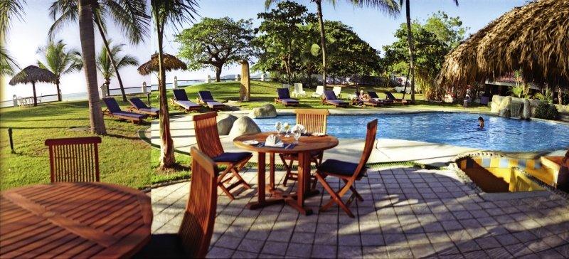 Außenpoolbereich des Bahia del Sol Hotels mit Liegestühlen und tiki-bar.