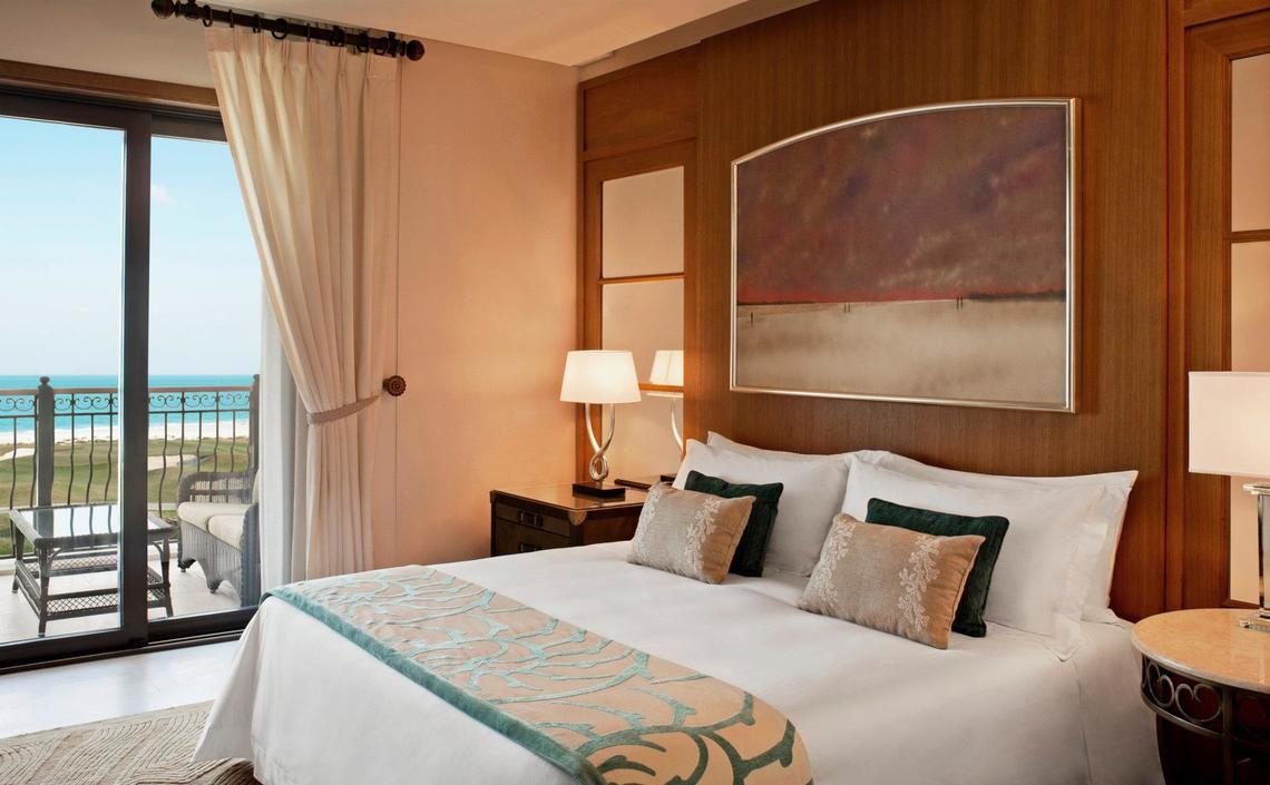 Hotelzimmer im St. Regis Saadiyat Island Resort mit Meerblick, Bett, Nachttisch und Balkon