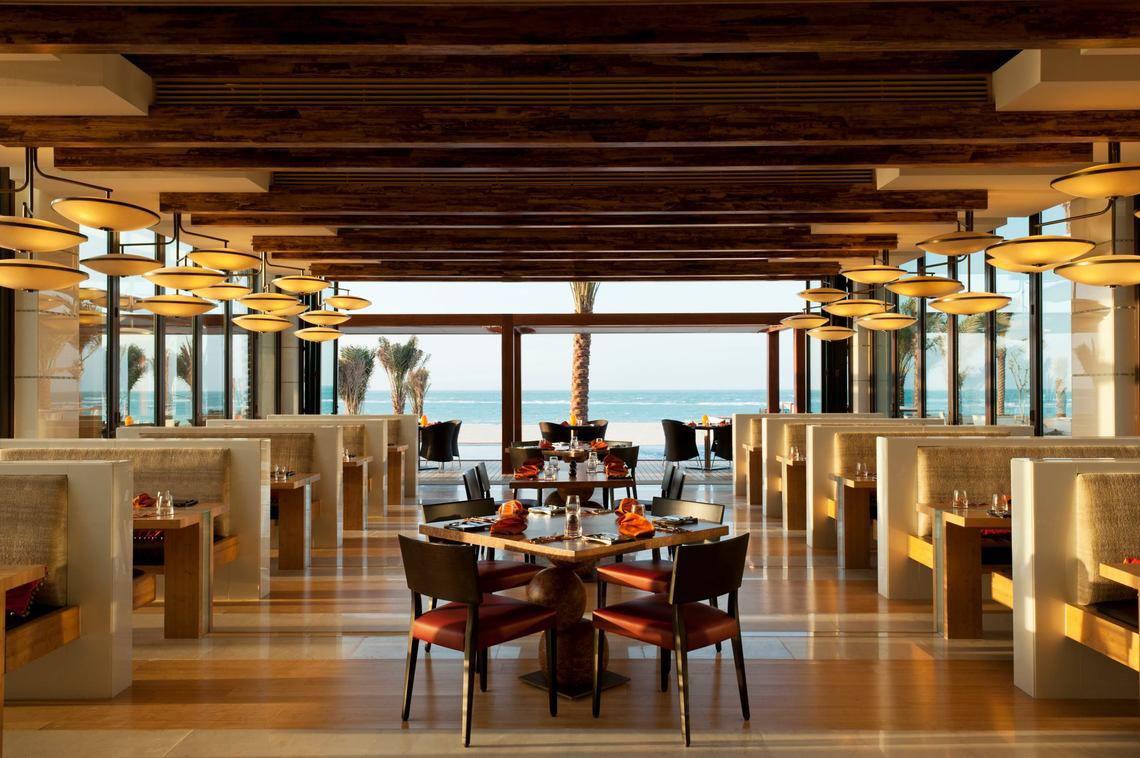 Innenansicht des Restaurants im St. Regis Saadiyat Island Resort mit Blick auf das Meer.