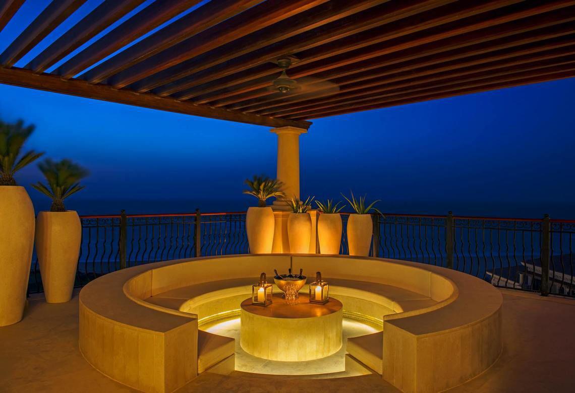 Terrasse des St. Regis Saadiyat Island Resort mit Blick auf den Ozean und beleuchteten Pflanzen.