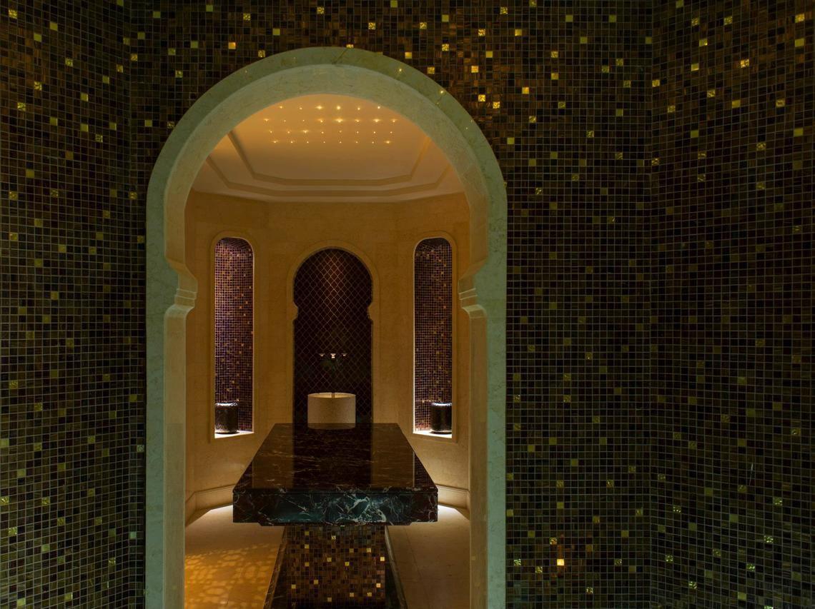 Inneneinrichtung des St. Regis Saadiyat Island Resort mit marmorner Theke und Mosaikwänden.