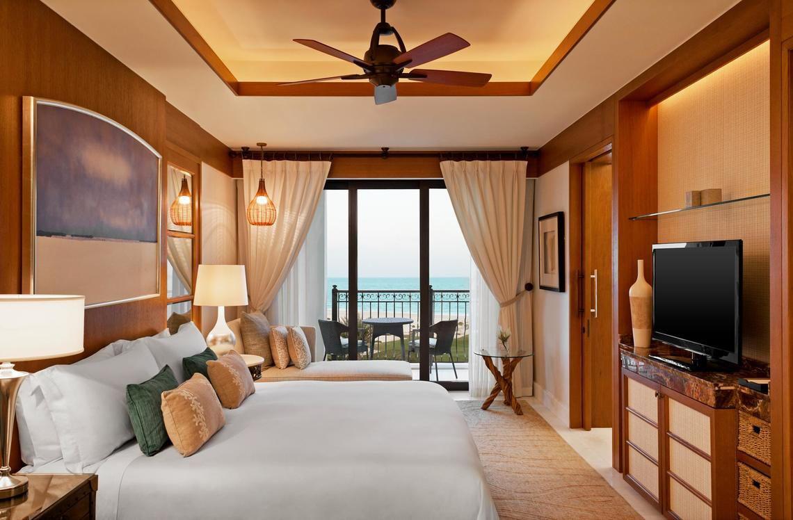 Schlafzimmer im St. Regis Saadiyat Island Resort mit Meerblick und Balkon.