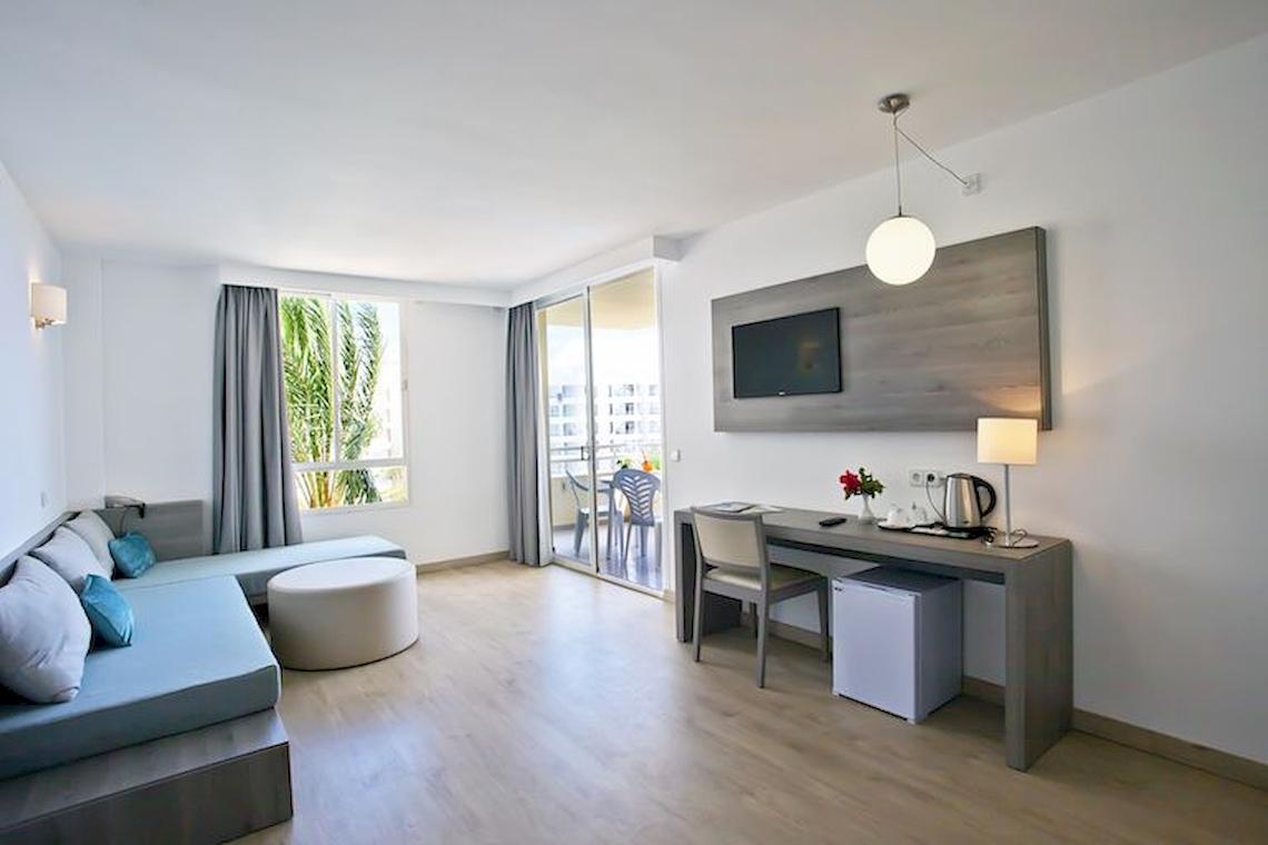 Innenansicht eines Zimmers im Playa Dorada Aparthotel mit Sofa, Schreibtisch und Fernseher.