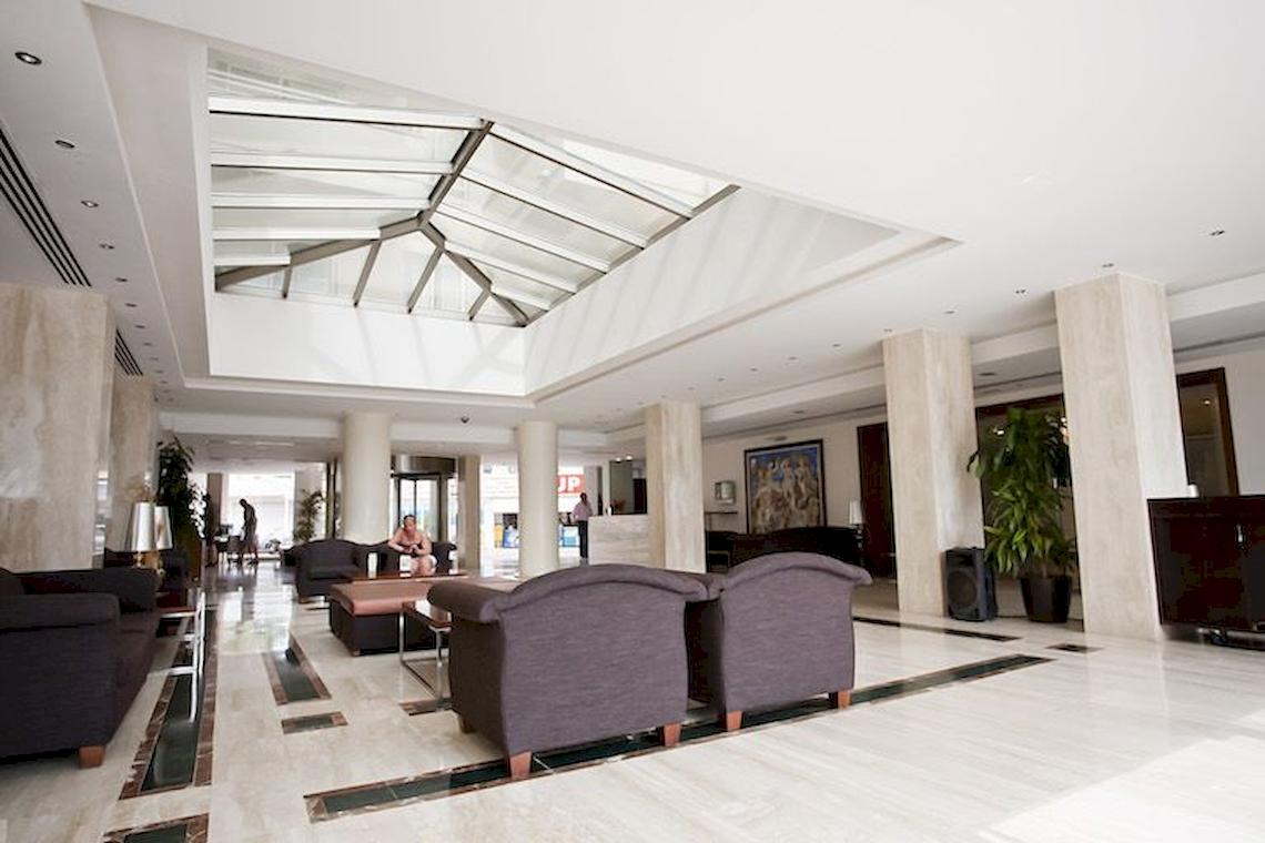 Hotellobby mit Couch und Glasdach im Playa Dorada Aparthotel