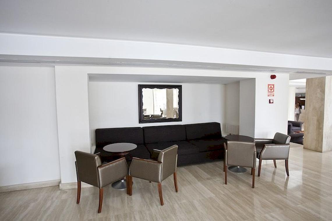 Loungebereich im Hotel Playa Dorada Aparthotel mit Sofa, Stühlen und Tischen.