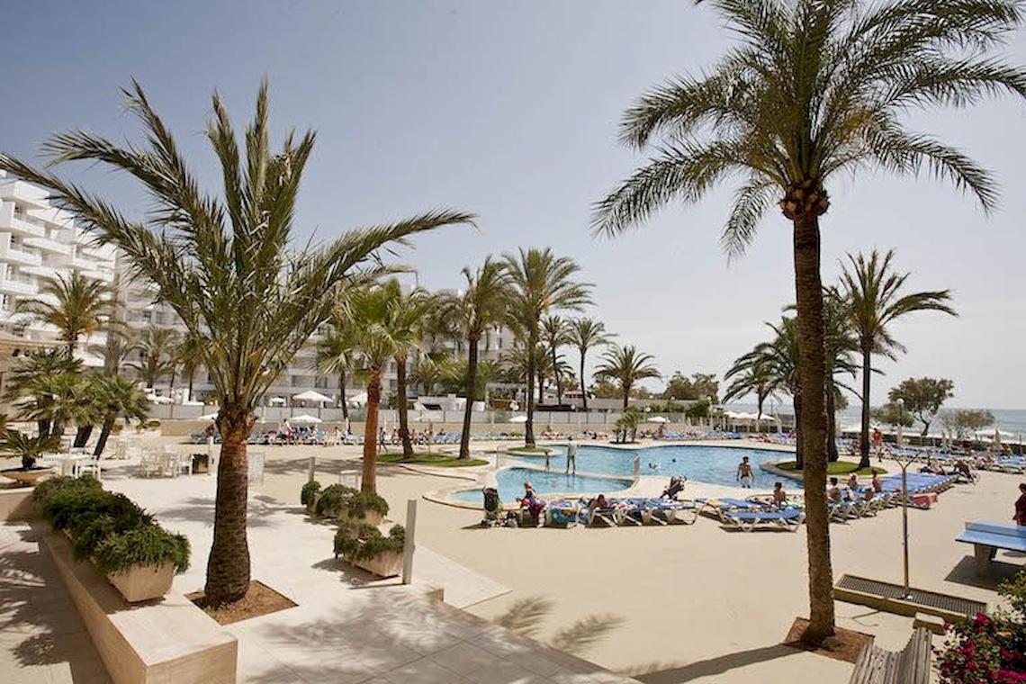 Außenpoolbereich des Playa Dorada Aparthotels mit Palmen und Sonnenliegen.
