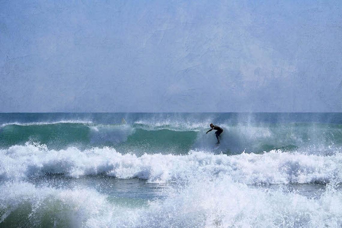 Surfer im Meer, der eine Welle reitet