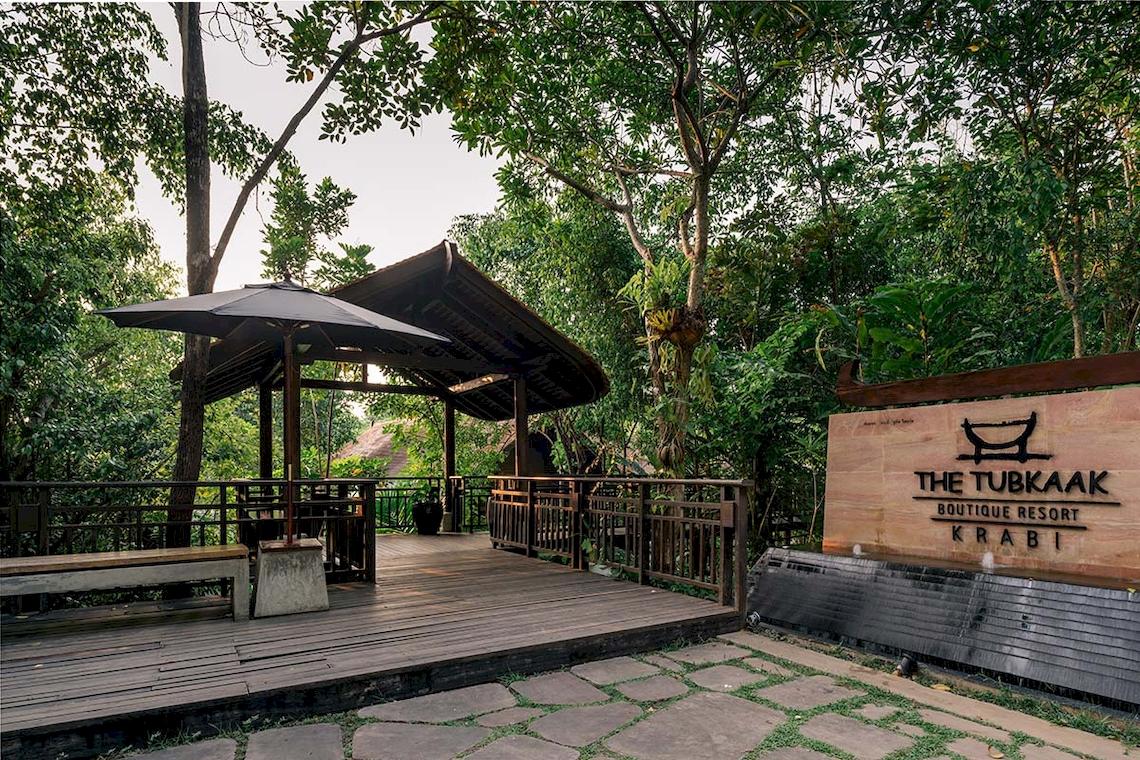 Eingangsbereich des Tubkaak Krabi Boutique Resorts mit Holzterrasse und Pavillon.