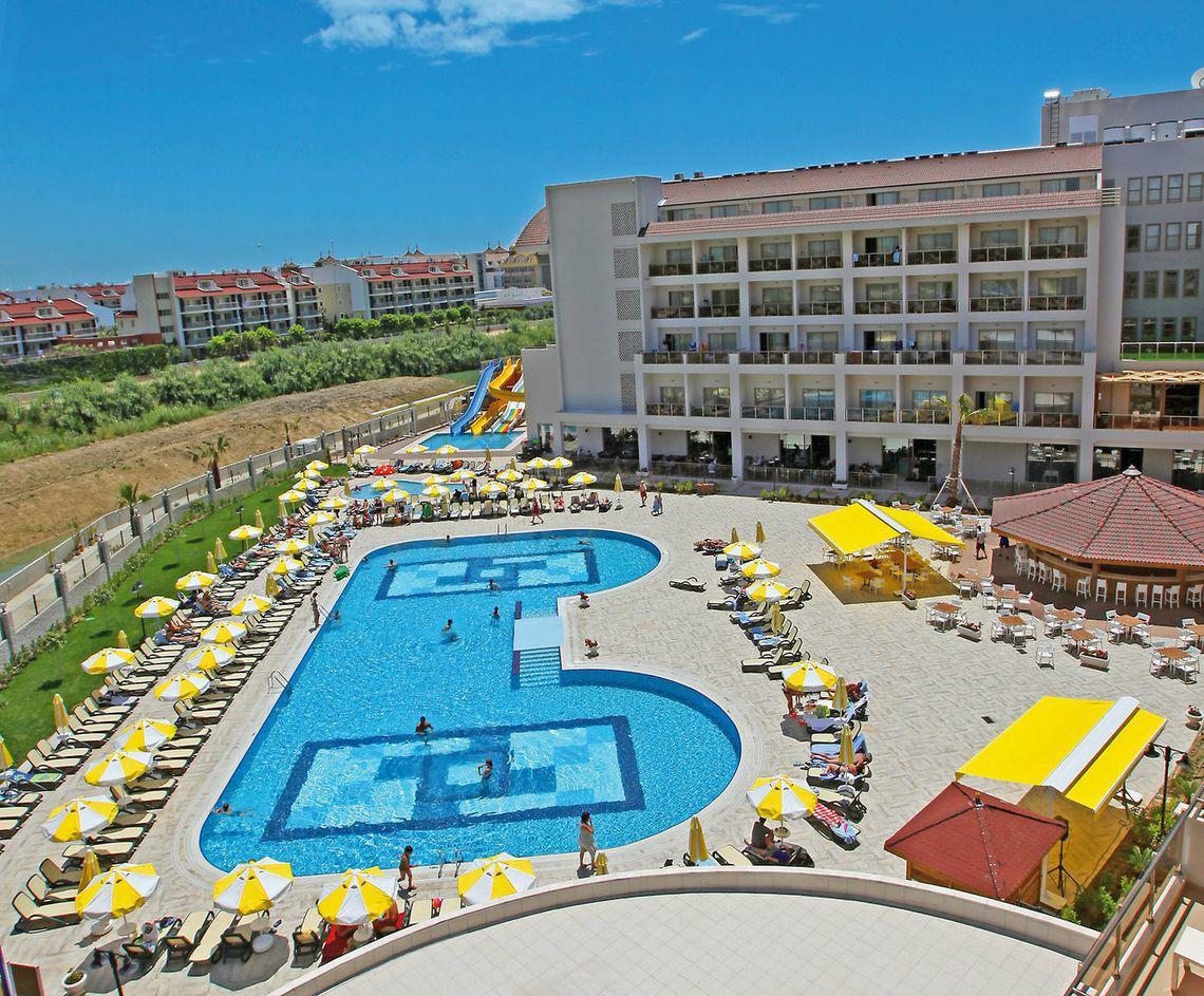 Außenbereich des Seher Sun Palace Resort & Spa mit Pools, Sonnenliegen und Sonnenschirmen.