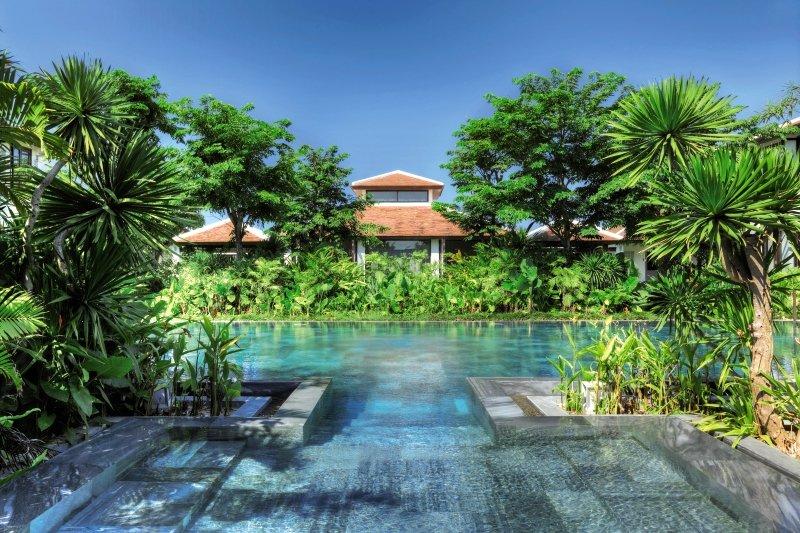 Außenpool des TIA Wellness Resorts, umgeben von Pflanzen und Bäumen.