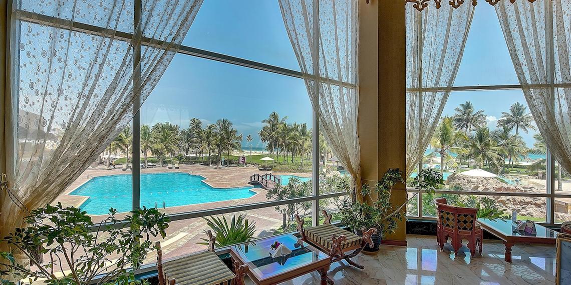 Ausblick des Crowne Plaza Resort Salalah auf den Swimmingpool und die Außenlandschaft.