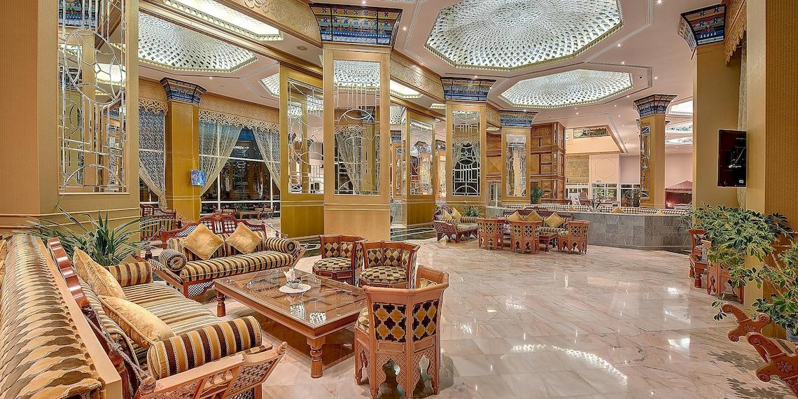 Lobby des Crowne Plaza Resort Salalah mit Möbeln und Pflanzen.