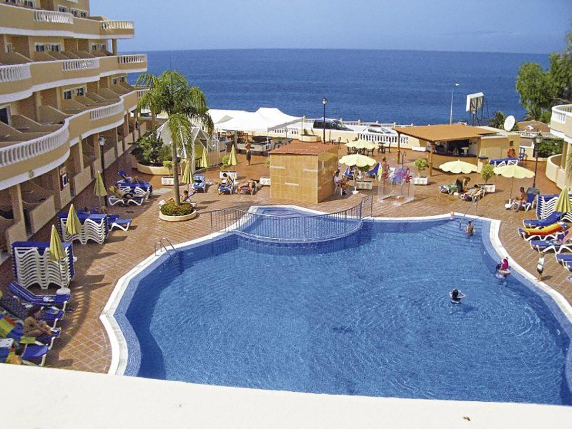 Außenpool des Bahia Flamingo Hotels mit Meerblick und Liegestühlen.