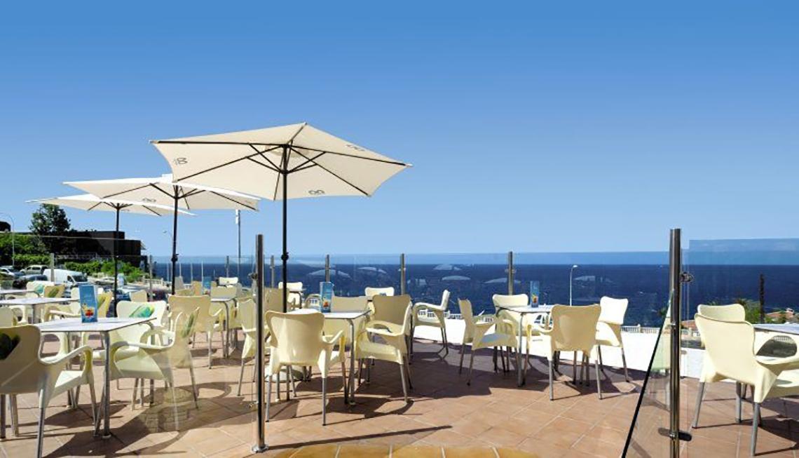 Terrasse des Bahia Flamingo Hotels mit Blick auf das Meer und weißen Sonnenschirmen