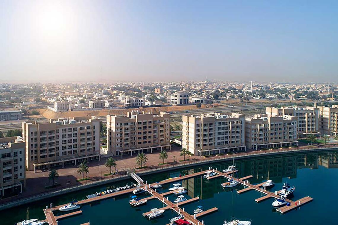 Luftaufnahme von Jannah Hotels Resorts & Villas mit Blick auf einen Hafen und mehrere Gebäude.