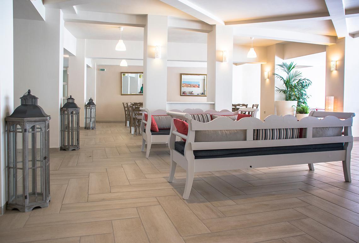 Innenbereich des Messonghi Beach Holiday Resort mit weißen Möbeln und Holzboden.