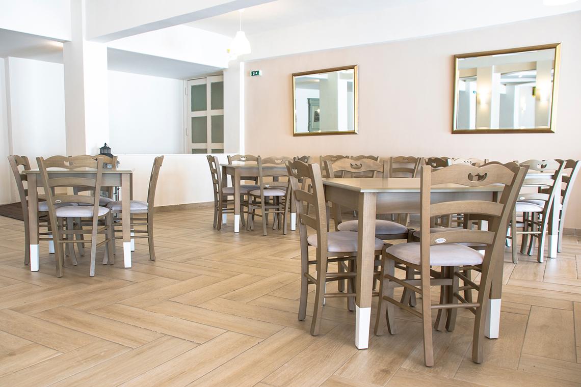 Innenansicht des Speisebereichs im Messonghi Beach Holiday Resort mit holzigen Tisch und Stühlen