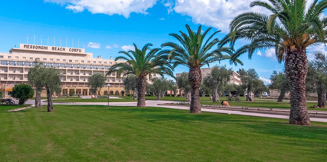Messonghi Beach Holiday Resort vorne mit Gras und Palmen.