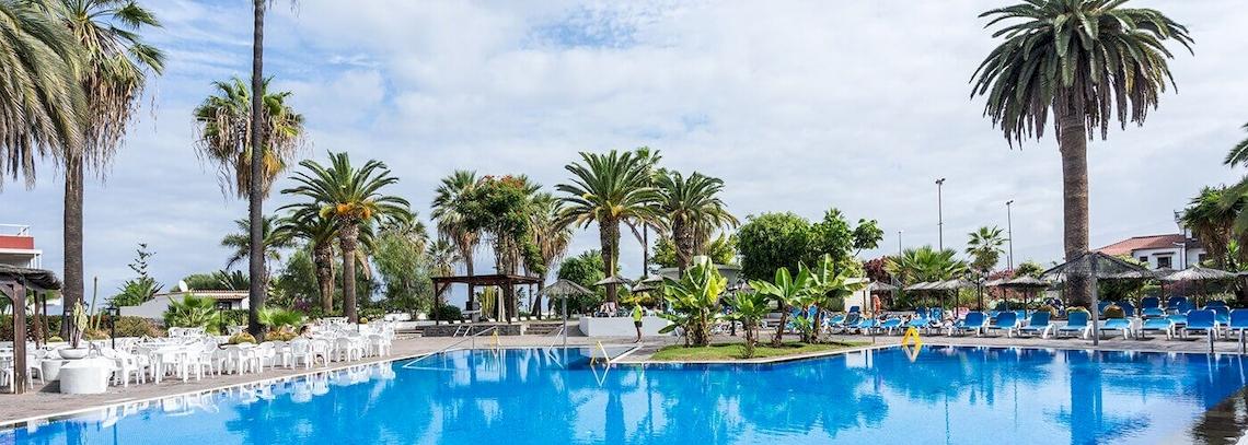 Poolbereich des Bluesea Interpalace Hotels mit blauem Wasser und Sonnenliegen