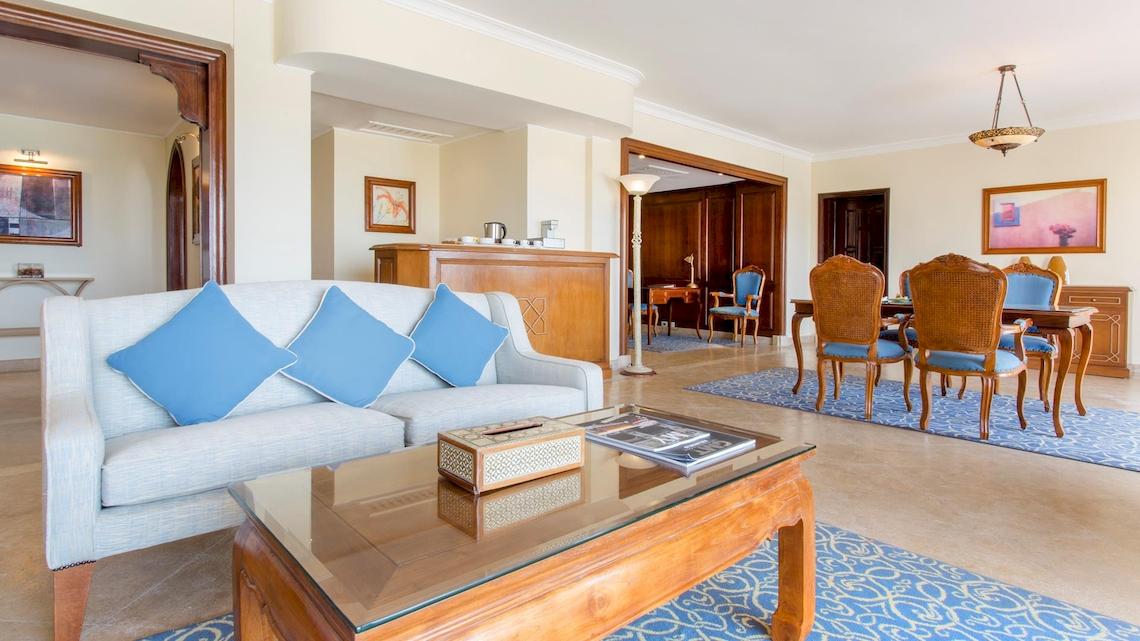 Wohnzimmer im Kempinski Hotel Soma Bay mit Sofa, Tisch, Esstisch und Stühlen.