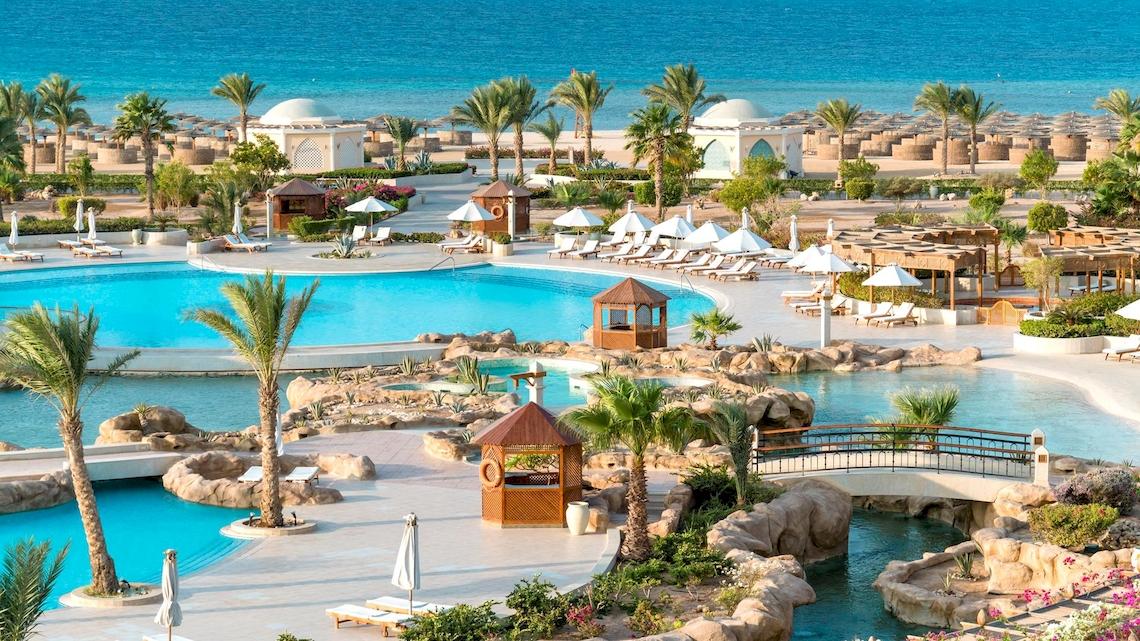 Luftaufnahme des Kempinski Hotels Soma Bay mit Swimmingpools, Sonnenliegen und tropischer Landschaft.