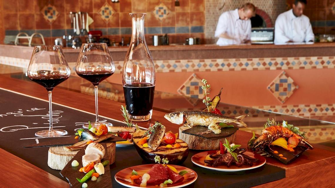 Frisch zubereitetes Buffet im Kempinski Hotel Soma Bay mit Weingläsern, Fisch und Gemüse.