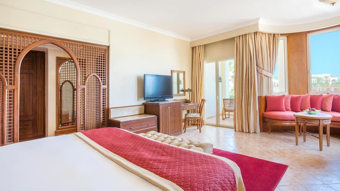 Suite-Zimmer im Kempinski Hotel Soma Bay mit Fernseher, Schreibtisch und Sofa.