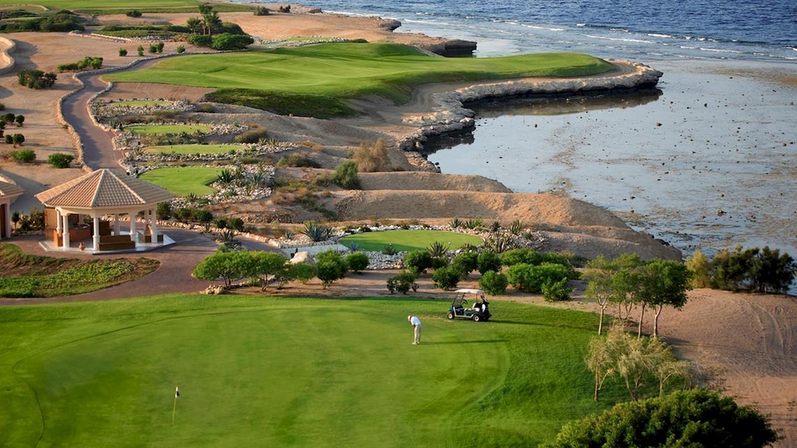 Luftaufnahme des Golfplatzes beim Kempinski Hotel Soma Bay mit Blick auf Wasser und Grün.