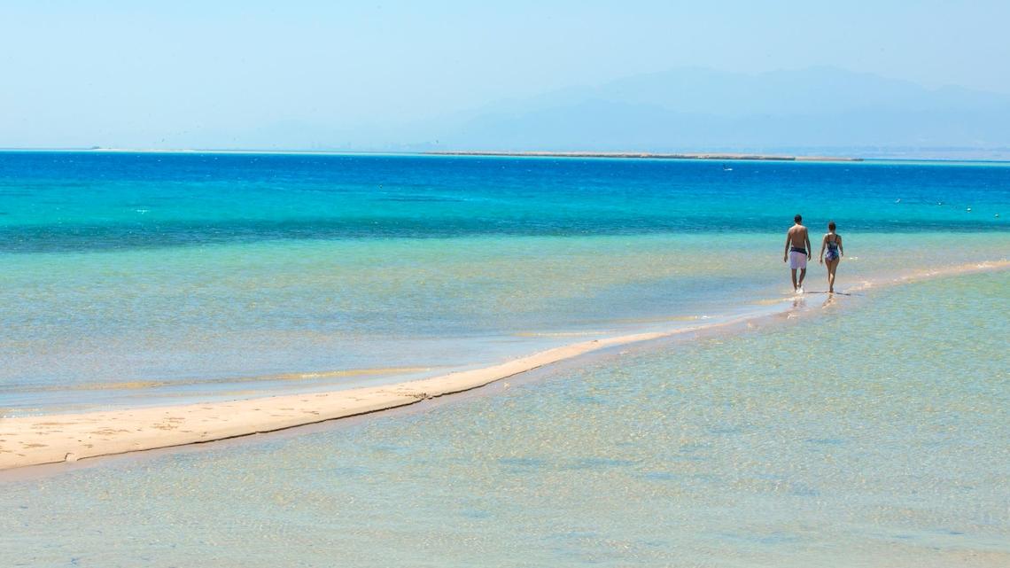 Zwei Personen laufen am Strand von Kempinski Hotel Soma Bay