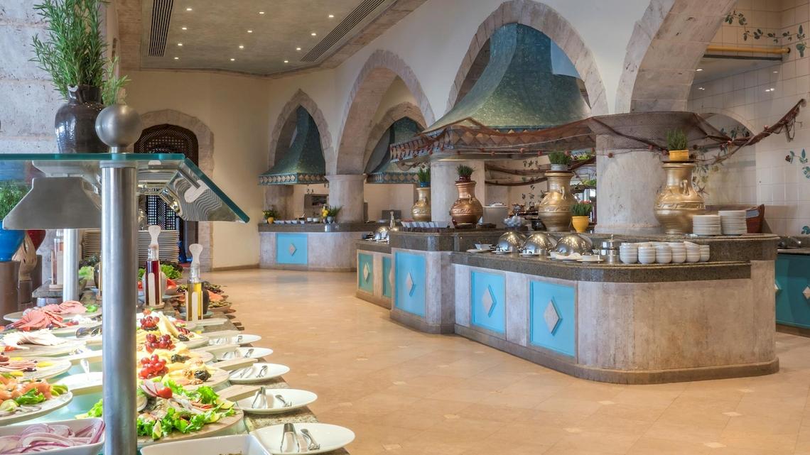 Buffetbereich im Kempinski Hotel Soma Bay mit verschiedenen Gerichten und blauen Säulen.