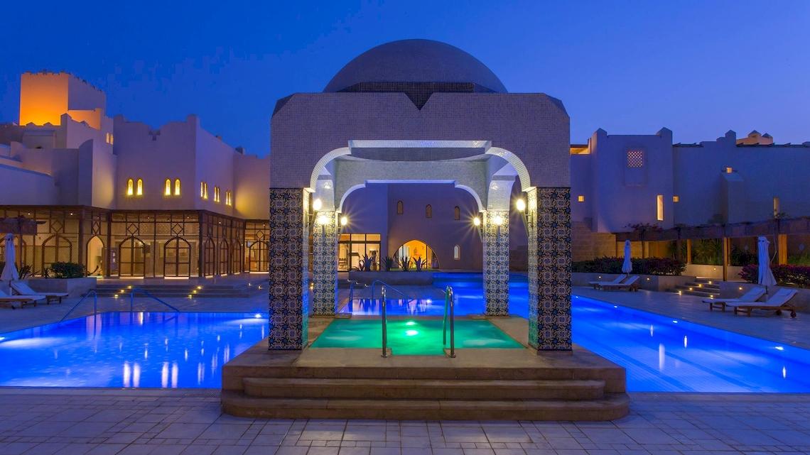 Nachtansicht des Swimmingpools im Kempinski Hotel Soma Bay, beleuchtet und einladend.