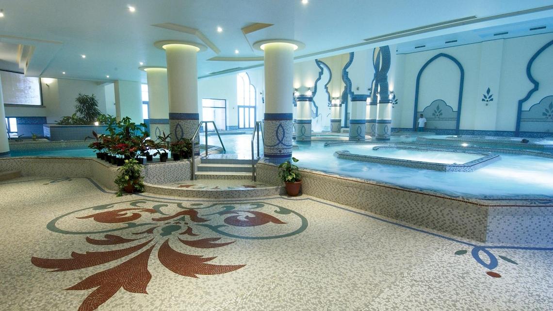 Innenpoolbereich des Kempinski Hotels Soma Bay mit zwei Becken, Säulen und Pflanzen.