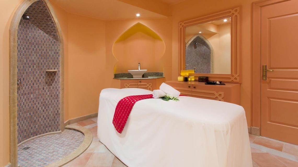 Spa-Behandlungsraum im Kempinski Hotel Soma Bay mit einem Behandlungsbett, einer Dusche und einem Waschbecken.