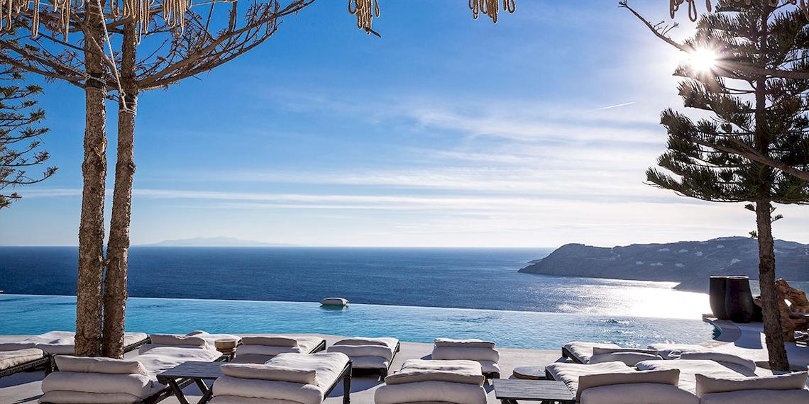 Ausblick auf das Meer vom Myconian Utopia Resort mit Sonnenlicht und weißen Sonnenliegen.