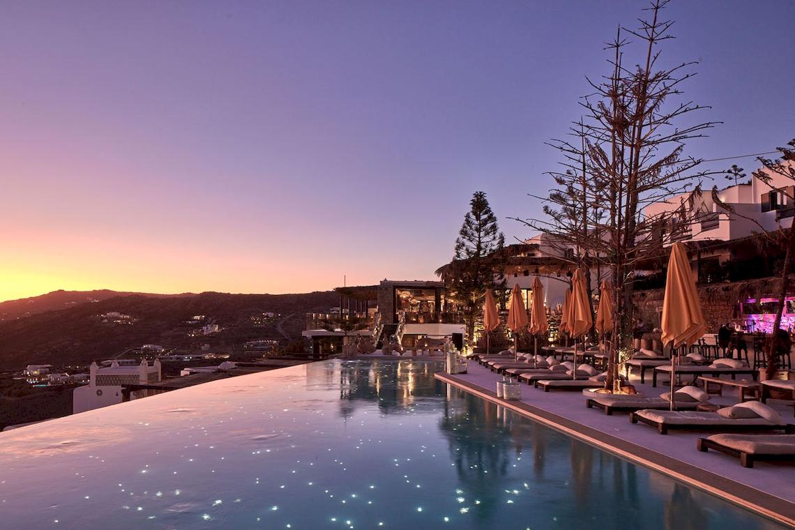 Infinity-Pool des Myconian Utopia Resorts bei Sonnenuntergang mit Blick auf den Horizont.