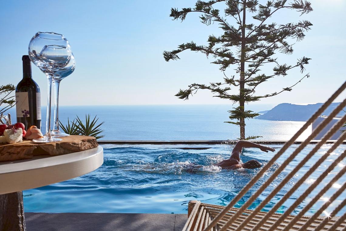 Schwimmer im Pool des Myconian Utopia Resorts mit Blick auf den Ozean